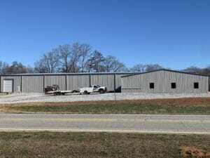 Large Custom Pre-Engineered Metal Building With Loaded Pickup Truck And Trailer Parked In Front. Custom Doors, Windows